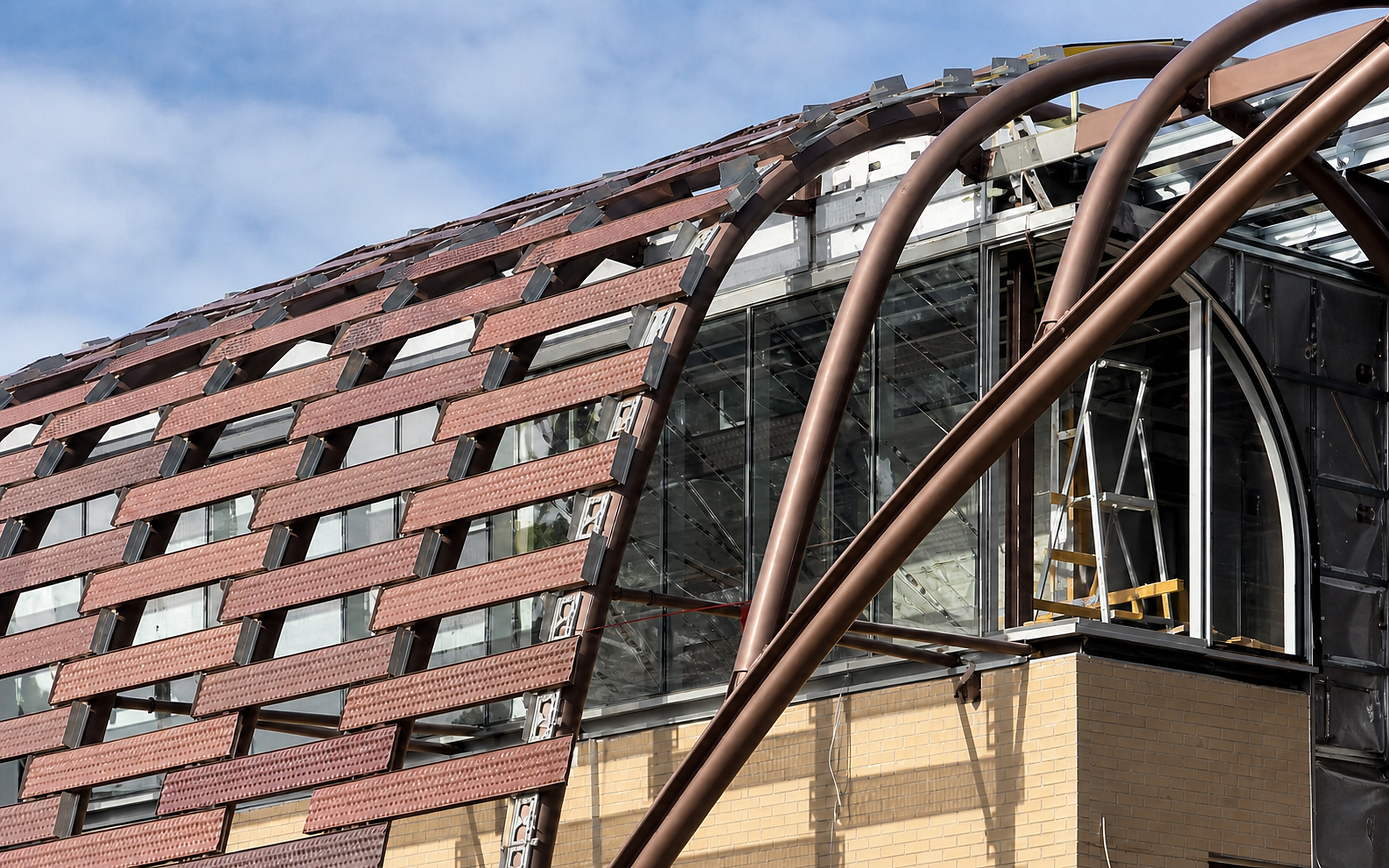 Close detail of woven metal facade and curved architectural steelwork